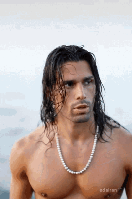 a shirtless man with long hair is wearing a pearl necklace edairan
