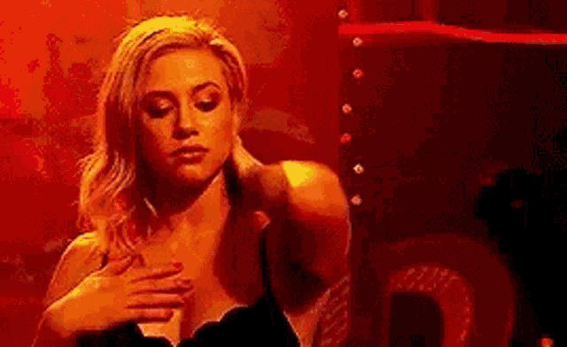 a woman in a bra is standing in front of a red light .