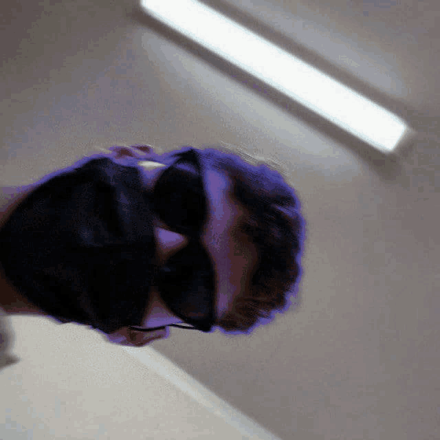 a man wearing sunglasses and a mask looks down