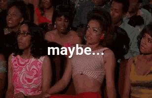 a woman in a striped top is sitting in a crowd of people and saying `` maybe ... '' .