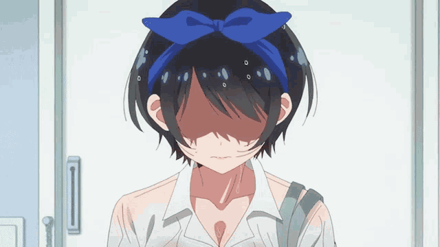 a girl with a blue bow on her head is covering her face with her hand