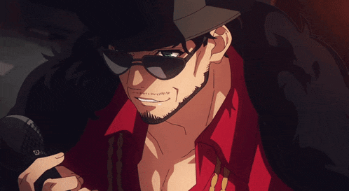 a man with a beard wearing sunglasses and a hat holds a microphone