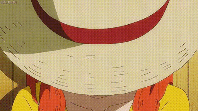 a close up of a person wearing a hat with a red ribbon on it .