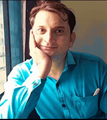 a man in a blue shirt has his hand on his face