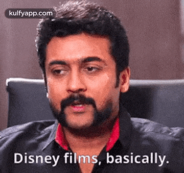 a man with a beard is sitting in a chair and talking about disney films .