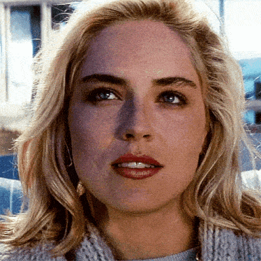 a close up of a woman 's face with a sweater on