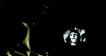 a person with a mask on their face and blood on their clothes