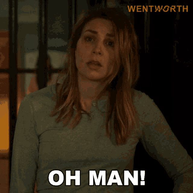 a woman in a green shirt says " oh man " in front of a sign that says wentworth