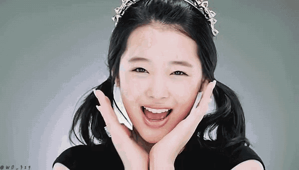 a young girl with pigtails and a tiara on her head