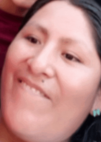 a close up of a woman 's face smiling and looking at the camera