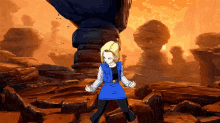 a woman in a blue dress is standing in a rocky area .