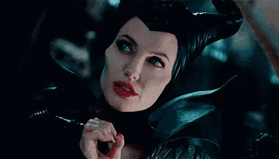 a woman with horns is holding her finger to her lips and says que mala eres ..
