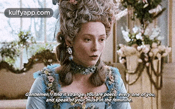 a woman in a blue dress and wig is talking to a man in a room .