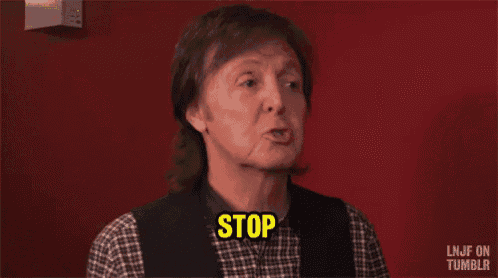 a man wearing a plaid shirt and vest is saying stop