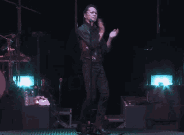 a man is dancing on a stage with a drum set in the background that says sonic foam