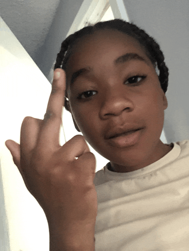 a young girl is giving the middle finger and looking at the camera