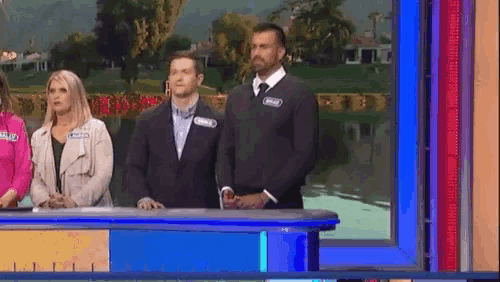 a group of people are standing on a stage in front of a blue screen .
