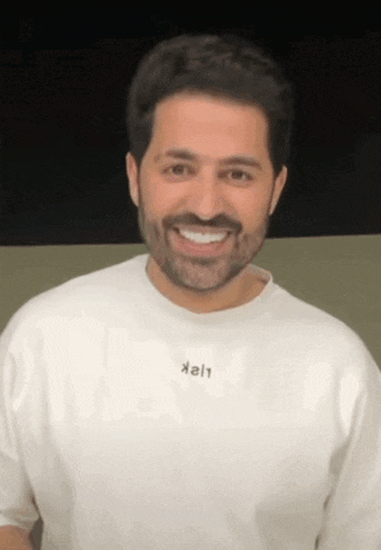 a man with a beard is wearing a white t-shirt that says kali on it
