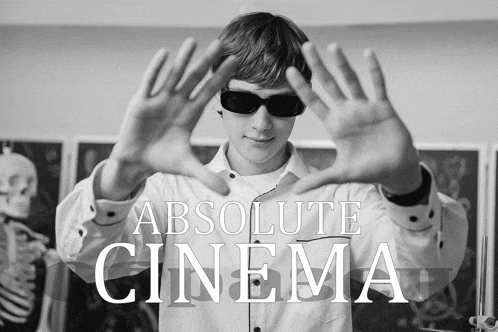 a man wearing sunglasses is making a frame with his hands with the words absolute cinema behind him