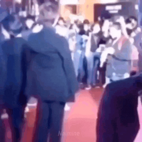 a group of people are standing on a red carpet in a room .