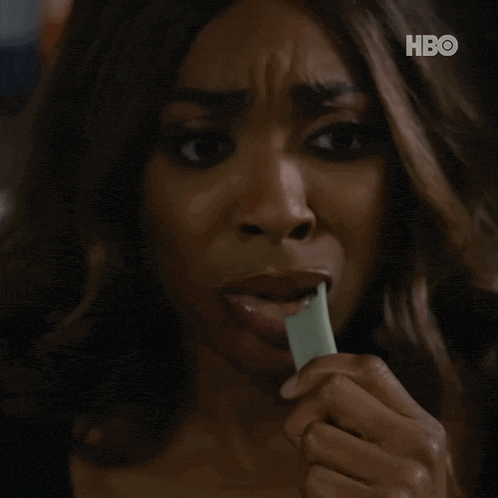 a close up of a woman eating an ice cream cone with hbo written on the bottom
