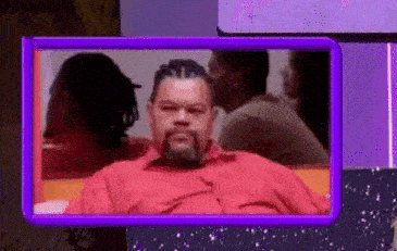 a man with a beard in a red shirt is sitting on a bench in a purple frame .