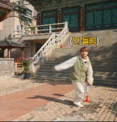 a person dancing in front of a building with chinese writing