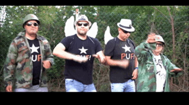 a man wearing a shirt that says puf is dancing with two other men