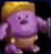 a purple stuffed animal with a crown on its head is holding a sword .