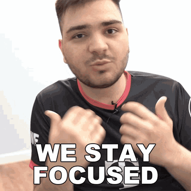 a man with a beard is giving a thumbs up with the words we stay focused below him