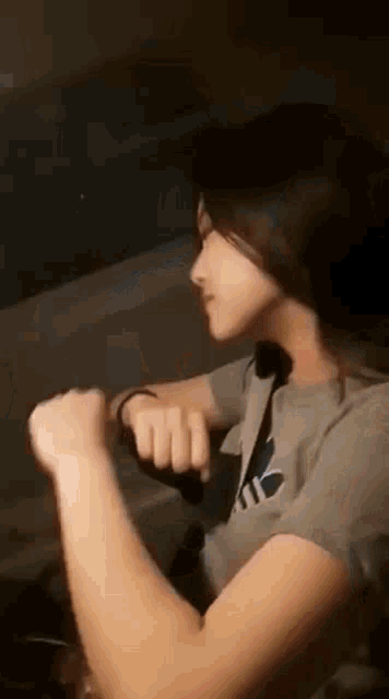 a woman is sitting in the driver 's seat of a car and making a fist .