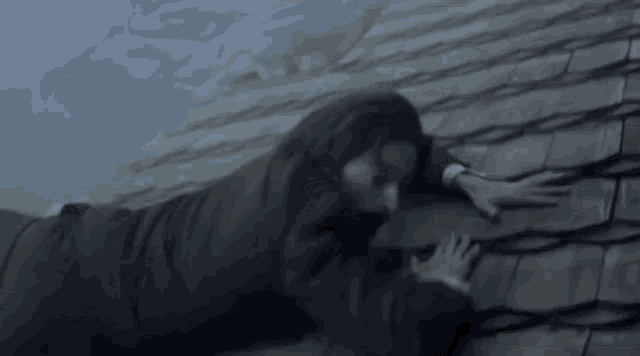 a man in a suit is crawling on the roof .