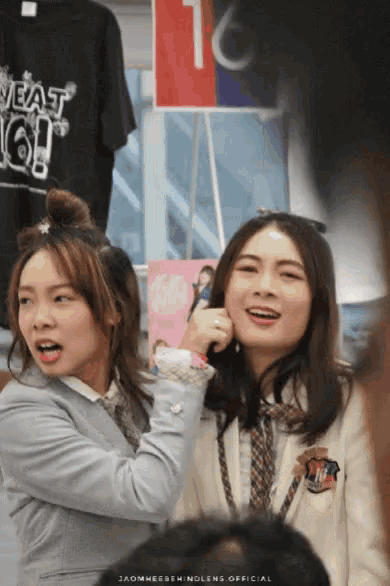 two girls are standing in front of a sign that says " sweat 16 "