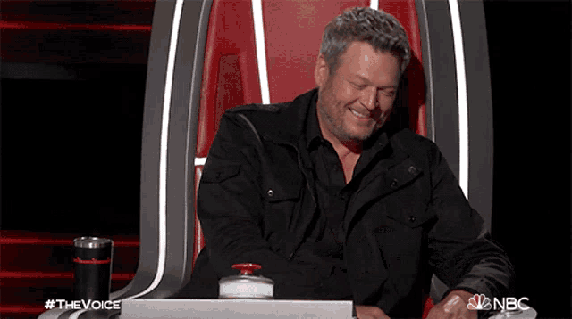 a man is sitting in a chair with a nbc logo on the bottom