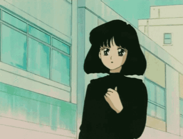 a girl in a black sweater stands in front of a building with the number 1 on it