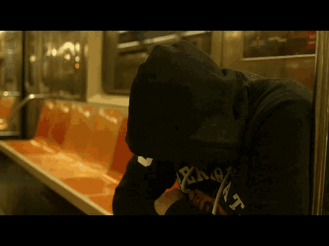 a person wearing a black hoodie that says x-a-r-a-t