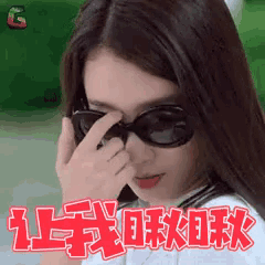 a woman wearing sunglasses is covering her eyes with her hand