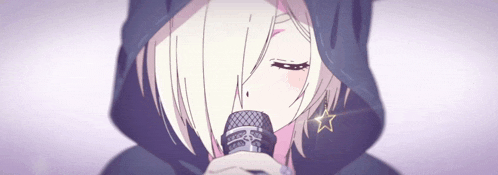 a girl in a black hoodie is singing into a microphone with her eyes closed