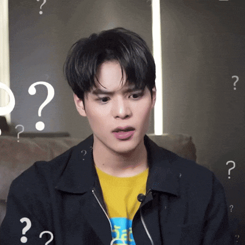 a man wearing a yellow shirt and a black jacket has many question marks around his head