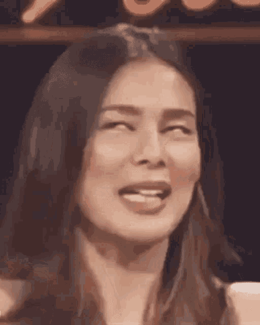 a close up of a woman making a funny face with her tongue sticking out .