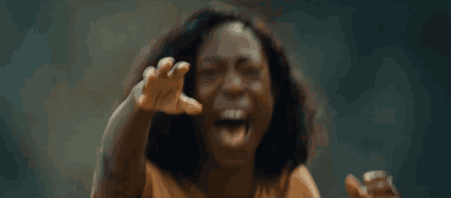 a woman is screaming and pointing her finger at the camera