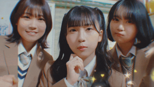 three girls in school uniforms pose for a photo