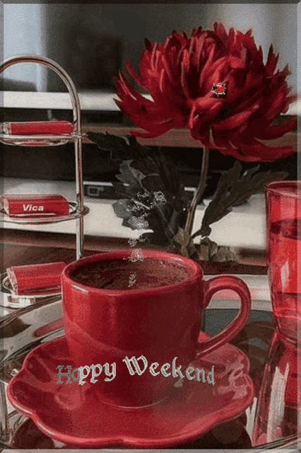 a red cup of coffee sits on a saucer with a happy weekend message