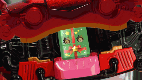 a toy with a green gift box on top of a pink block with the number 10 on it