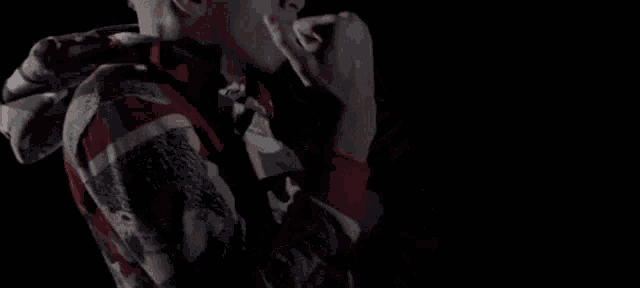the back of a man wearing a red , black and white hoodie .