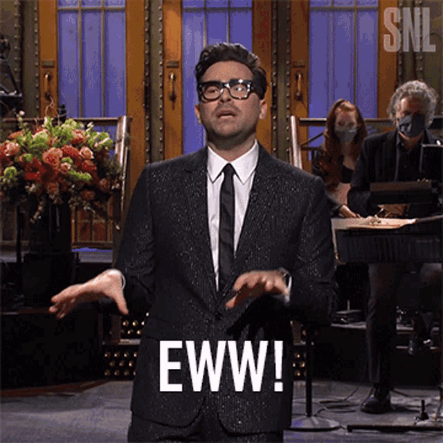 a man in a suit says eww in front of a snl logo