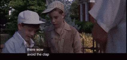 two boys wearing baseball caps are standing next to each other and one of them is saying there wow avoid the clap .