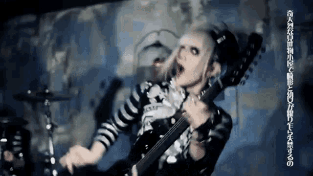 a woman is playing a guitar in a dark room .
