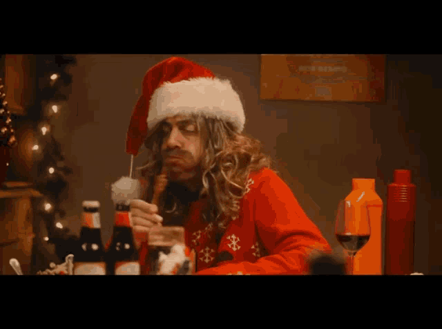 a man wearing a santa hat is sitting at a table
