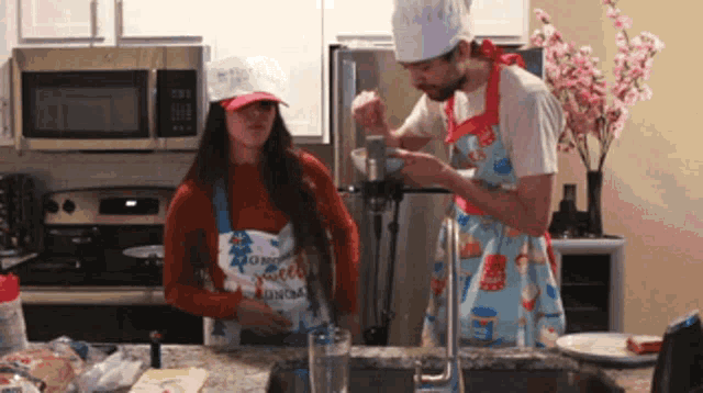 a man and a woman are in a kitchen wearing aprons that say good morning on them